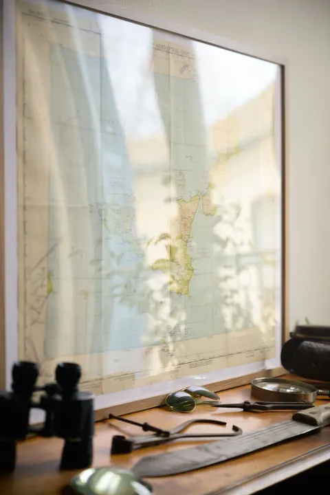 Bureau face à la fenêtre, jumelles posées sur la table