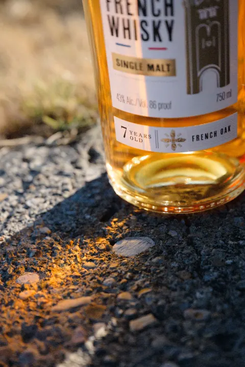 Bouteille de whisky Soubeyran posée au sol dans la lumière rasante