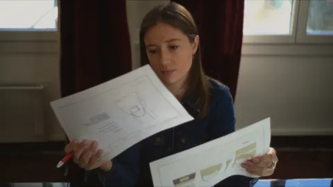 Créatrice de Carmen & Simone étudiant ses croquis de sacs