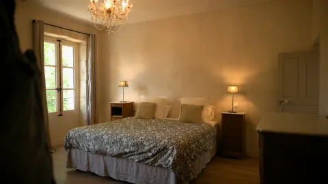 Chambre d'hôtes éclairée par un lustre
